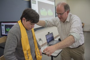 Honors Program Director Prof. Thomas Maulucci presents senior Cole Ludorf with his honors sash.