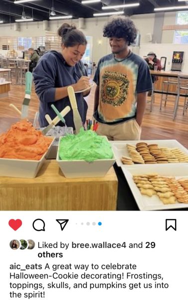 Tabatha Aponte, Manik Martins decorating Halloween cookies provided during a Lunch time event sponsored and posted on AIC_eats, the AIC Dinning Services Official Instagram